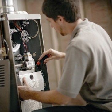 A technician servicing a residential furnace